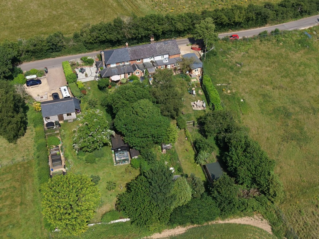 Lot: 134 - HOUSE FOR IMPROVEMENT WITH EXTENSIVE GARDEN - Overhead drone photo of the cottages